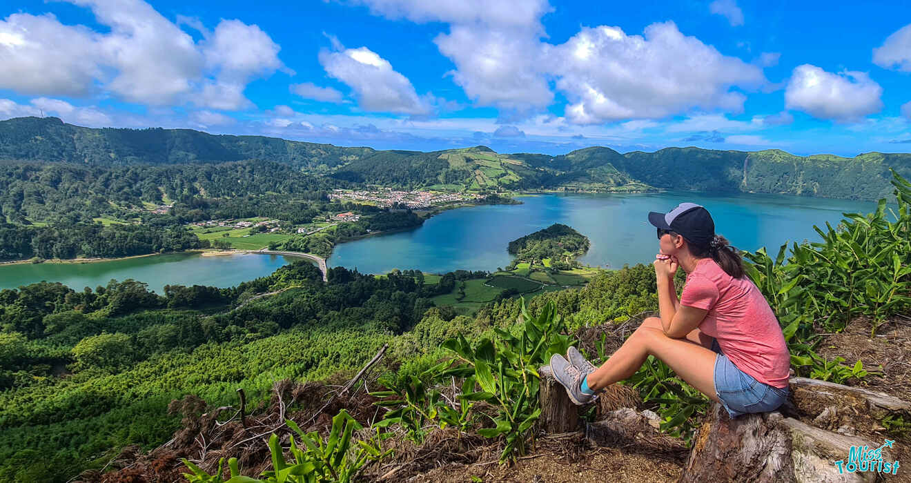 a person sitting on a rock overlooking a lake and mountains